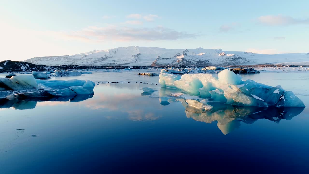 아이슬란드의 하 빙산 위에 있는 해파리의 아름다운 풍경, 푸른 바다에서, 해가 지는 배경에는 빙하가 있다.