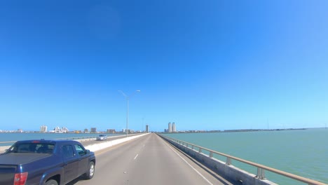 pov conduciendo en la calzada de la reina isabella hacia las torres de condominios en la isla del padre sur y pasando el área pantanosa
