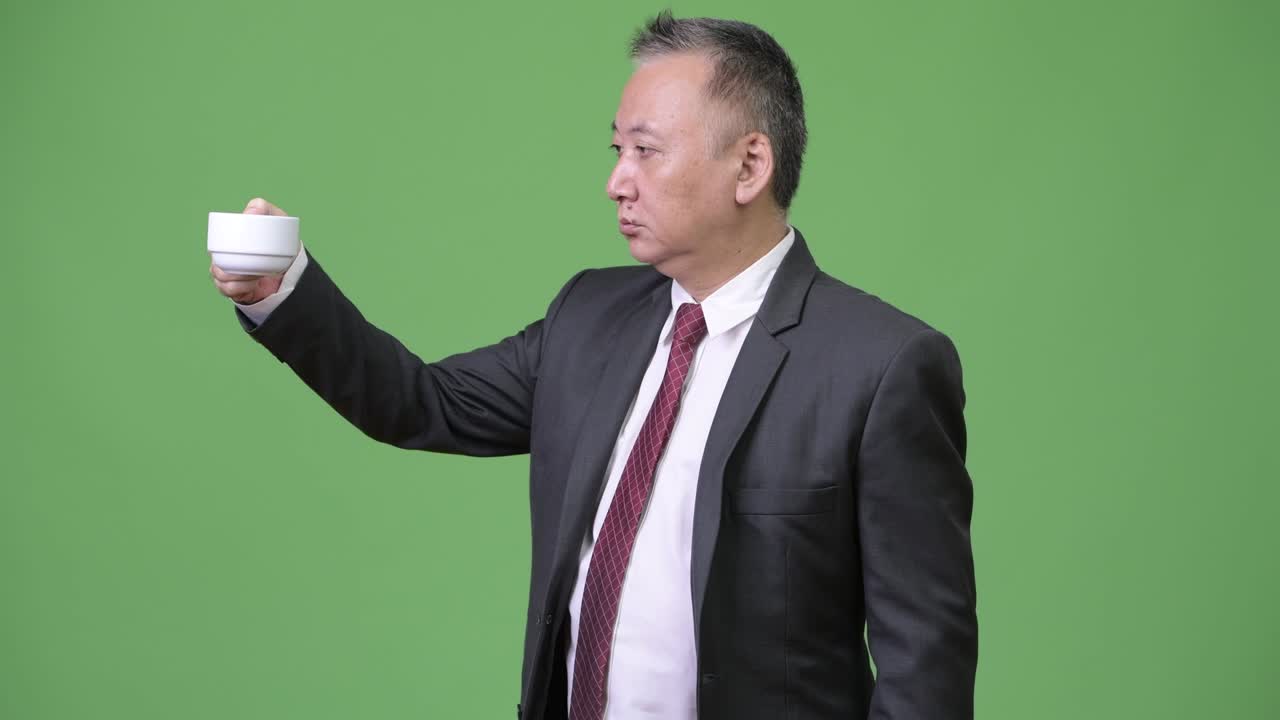 커피 컵 을 거꾸로 들고 있는 성숙 한 일본인 사업가