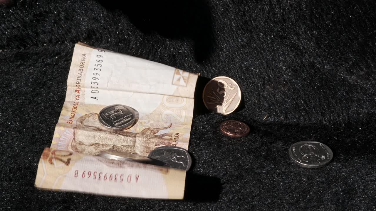 dinero en forma de billetes de papel y monedas que se arrojan a la caja de la guitarra de un músico callejero