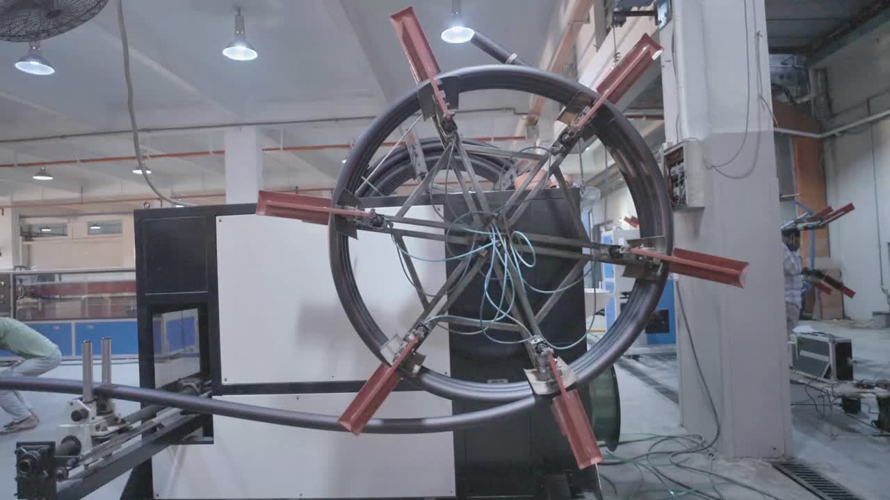 Shot of a big wheel of a machine rotating slowly in PVC Pipe Making Factory in Karachi, Pakistan. Automated.