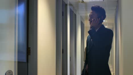 hombre de negocios hablando por teléfono móvil en la oficina 4k
