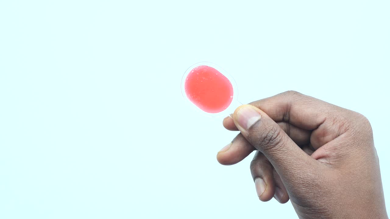 mano con una piruleta roja