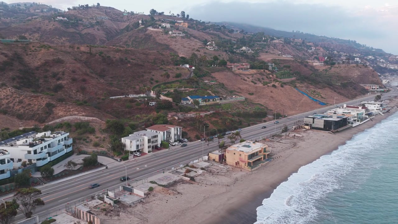 Ripresa aerea in discesa e panoramica di proprietà bruciate sul lungomare a Carbon Canyon a Malibu, California. 4K