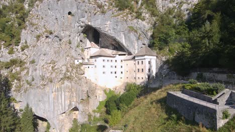 Drone-shot-over-Predjama-near-Predjama-Castle,-connected-to-Postojna-cave