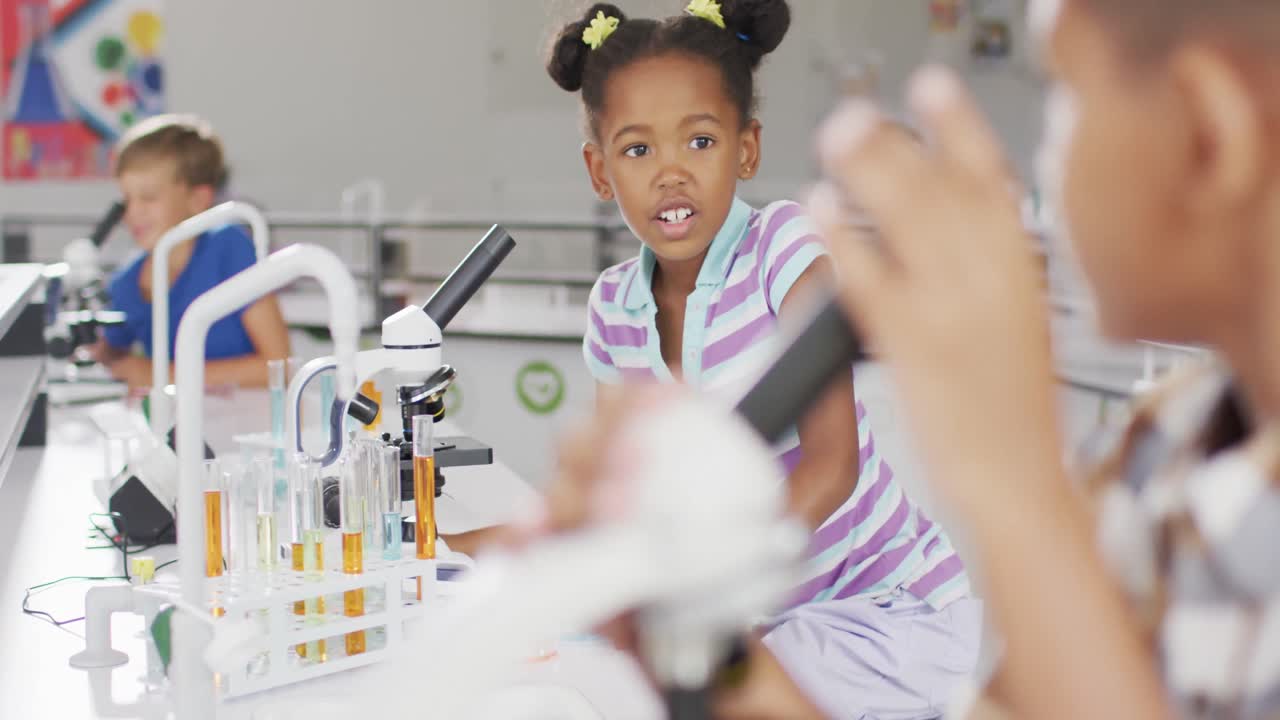 Video of happy african american girl with microscope during lesson