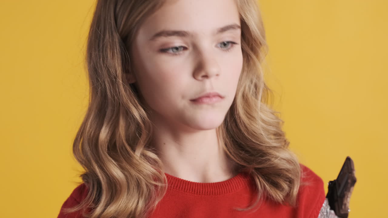 кавказская девушка-подросток ест шоколад и кивает головой.