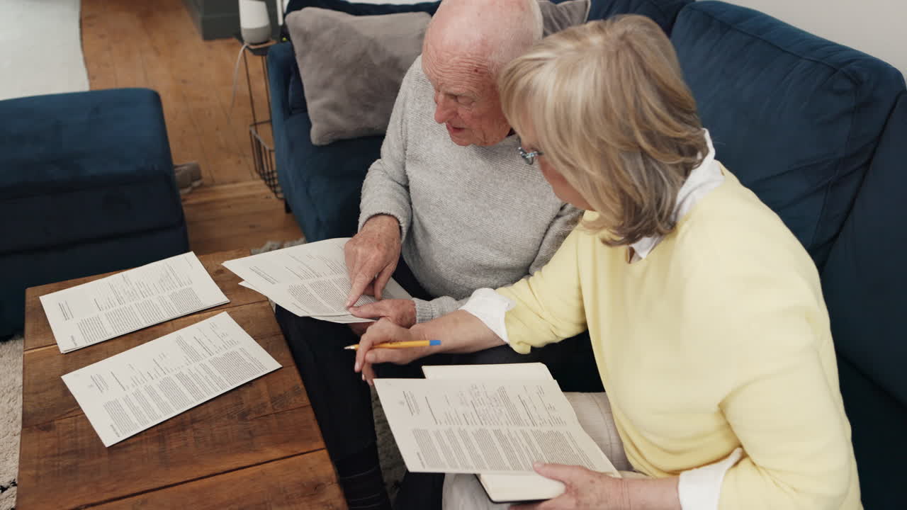 pareja de ancianos revisando documentos en casa