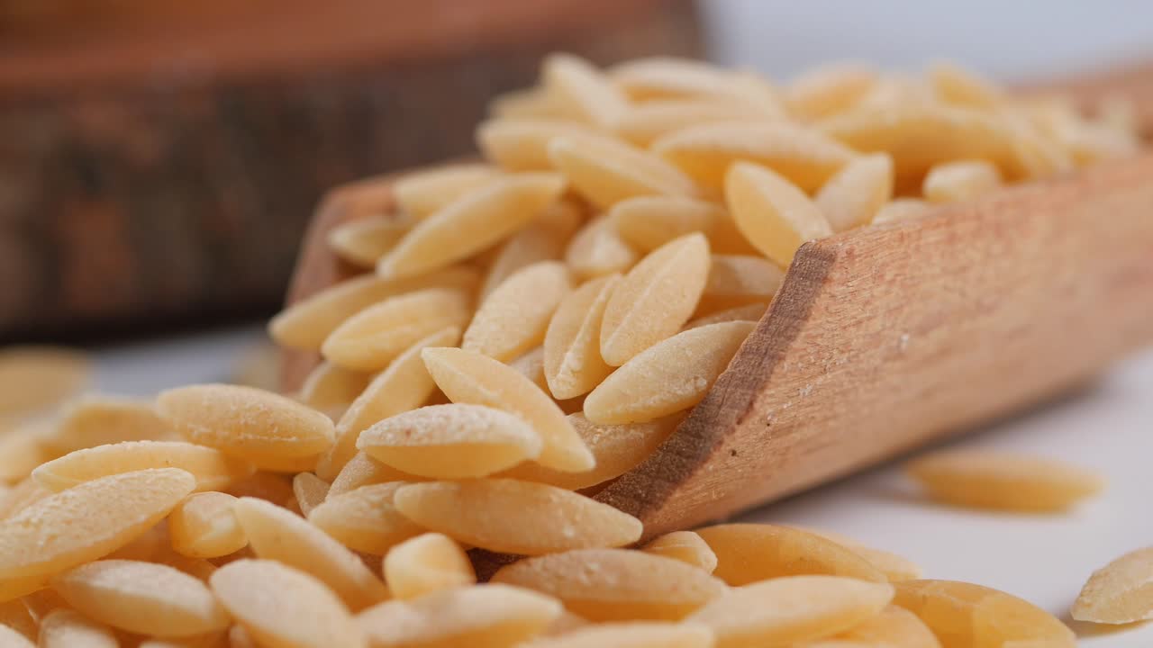 Orzo pasta in wooden spoon