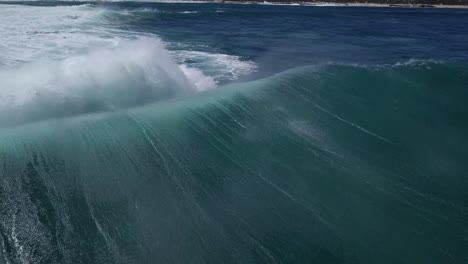 waves breaking over shallow reefs from the back with a drone