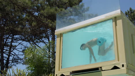 boy upside down in a glass container pool