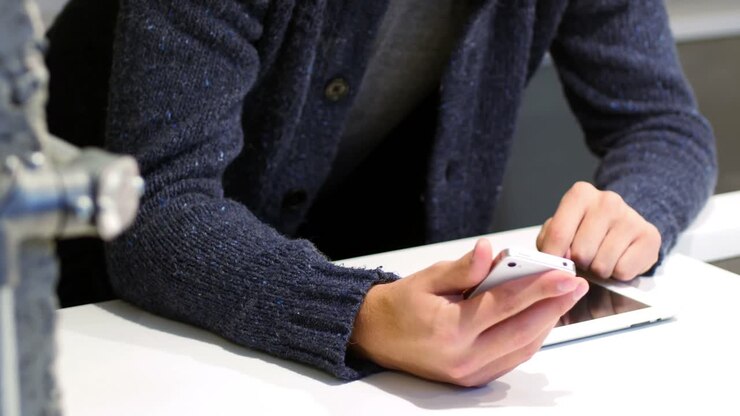 Mid-section of man using digital tablet and mobile phone