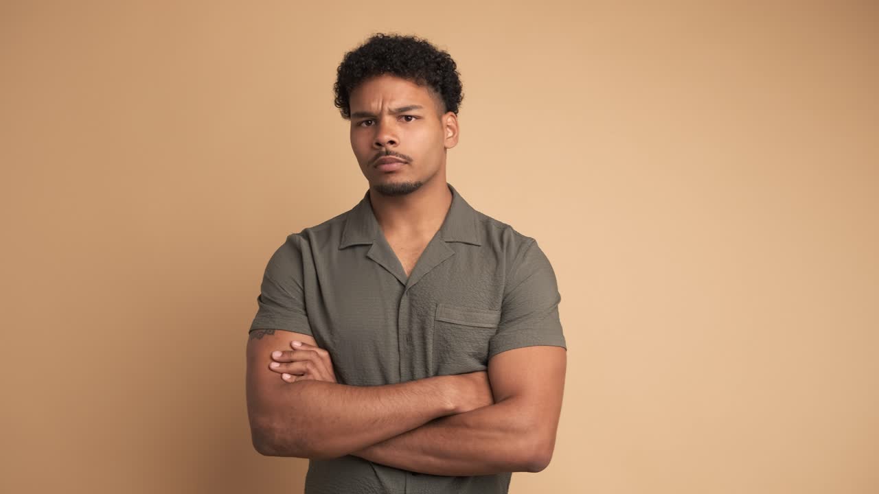 Disagreeing young man shaking head in beige studio