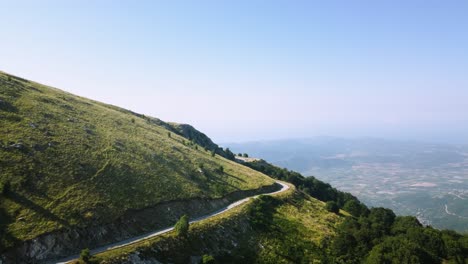 Antena-De-Una-Hermosa-Y-Estrecha-Carretera-De-Montaña-Con-Vistas-Al-Valle-Al-Amanecer.