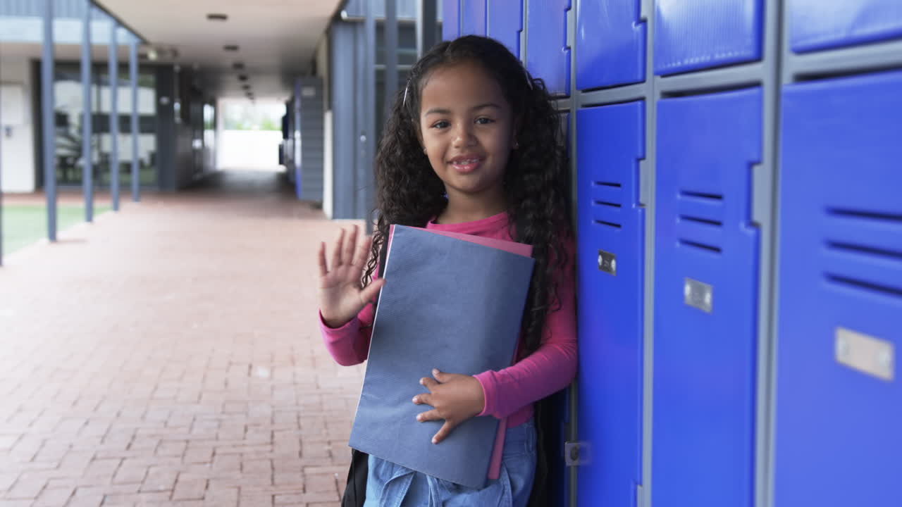 en un pasillo de la escuela, una joven de dos razas está de pie junto a casilleros azules con espacio para copiar