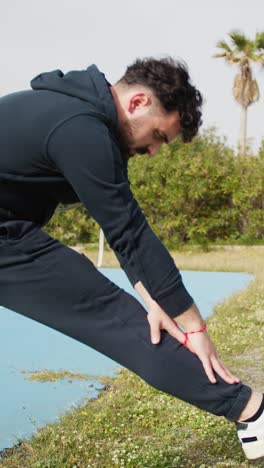 basketball player stretches his legs outdoors
