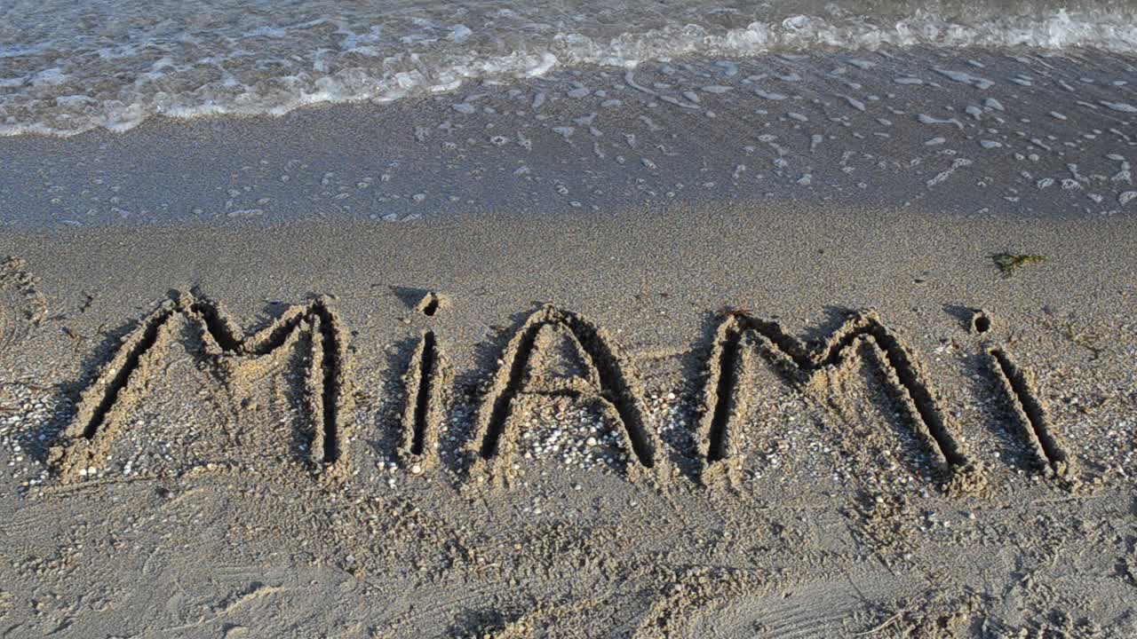 Inskriptionen 'Miami' på sanden. Inskription på sand.