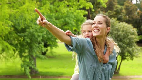 счастливая мать дает своей дочери свинью спину и указывает