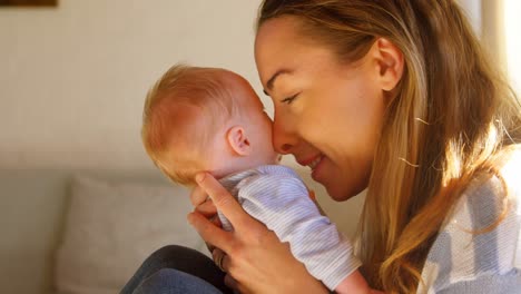 Mother-holding-her-baby-boy-in-living-room-4k