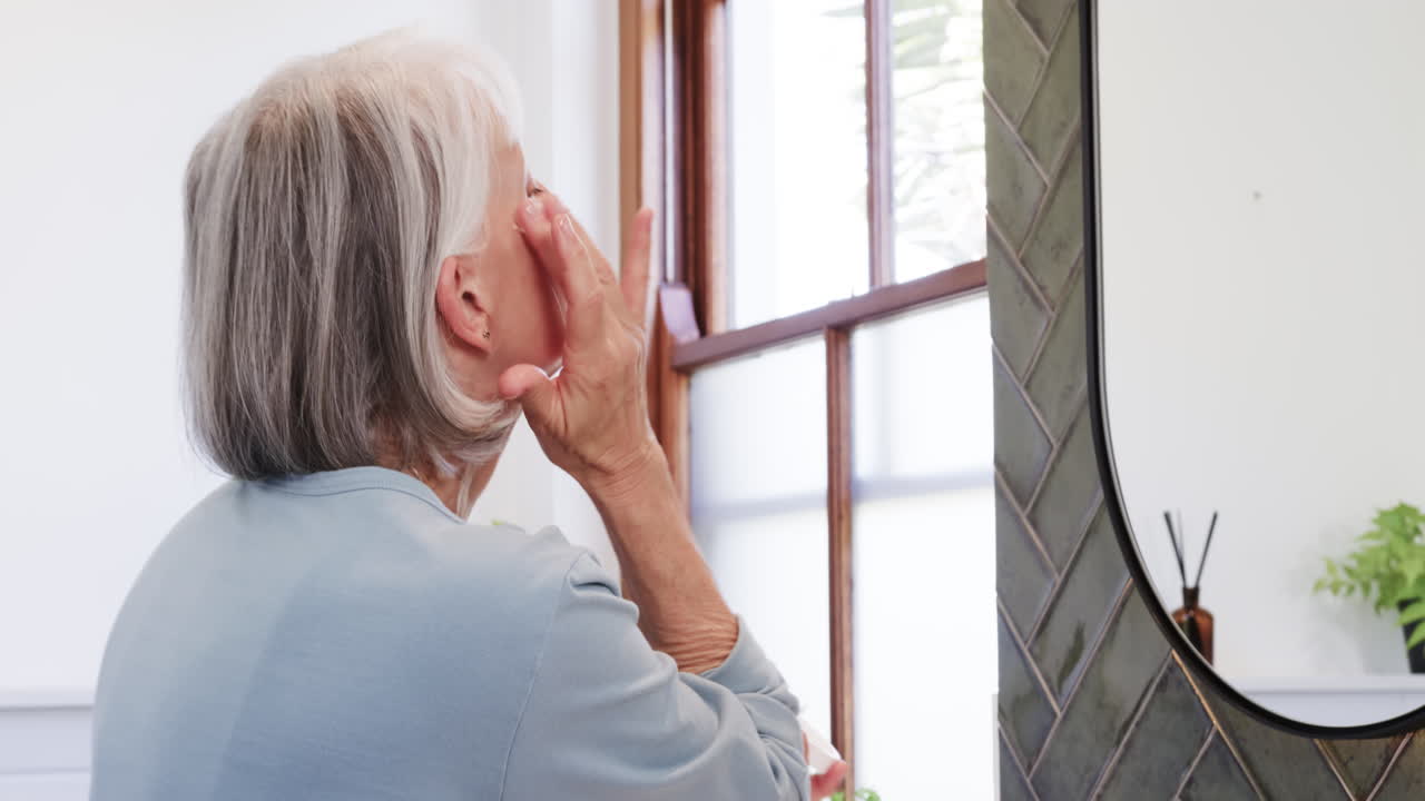 Senior woman reflecting in mirror at home, enjoying peaceful moment alone