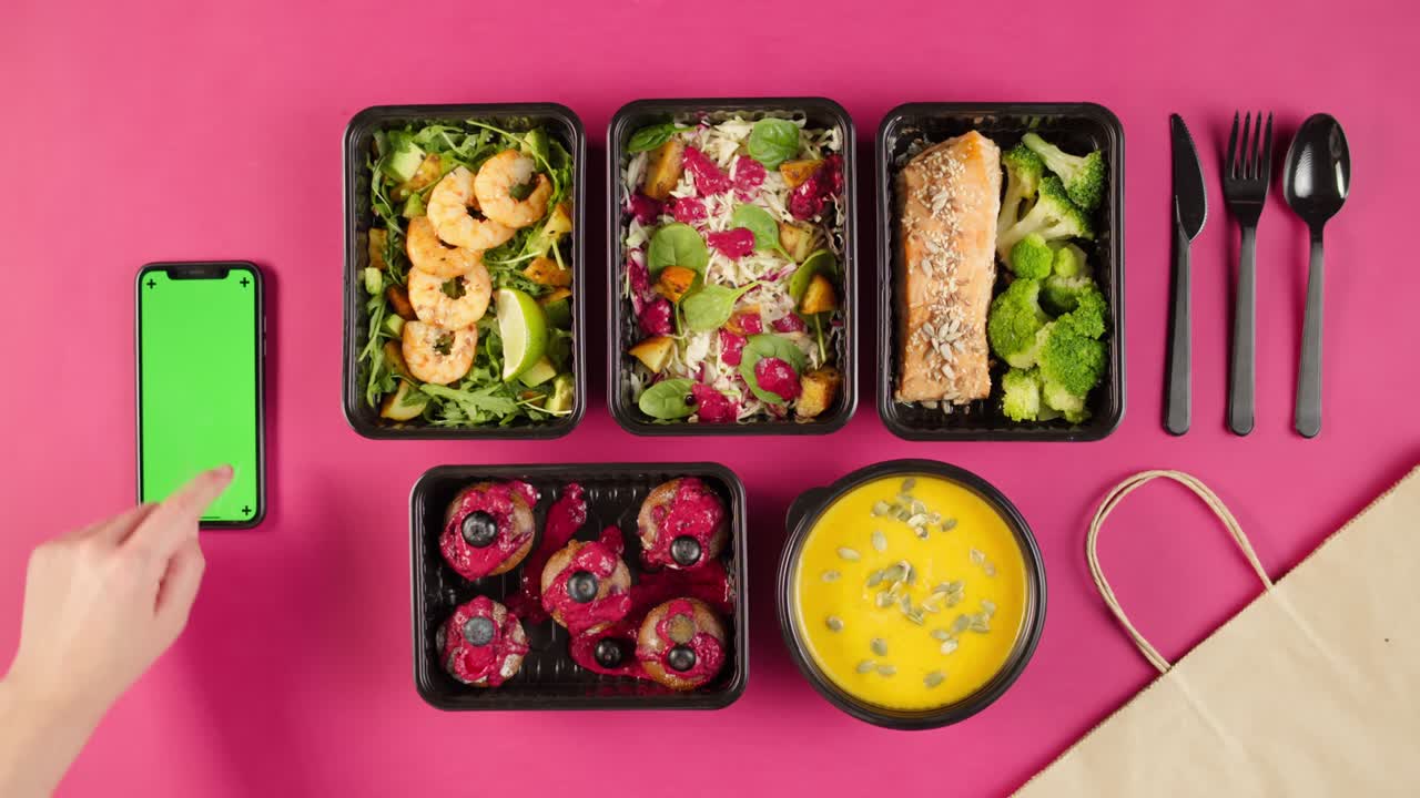 entrega de alimentos vista superior, llevar comidas en contenedores desechables en fondo rosa. cajas de almuerzo con platos vegetarianos cocidos, usando teléfono con pantalla verde croma. dieta saludable. servicio de catering
