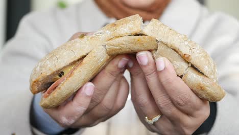 person holding a broken sandwich