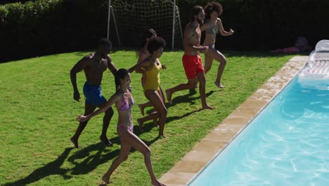 Grupo-Diverso-De-Amigos-Divirtiéndose-Saltando-A-Una-Piscina