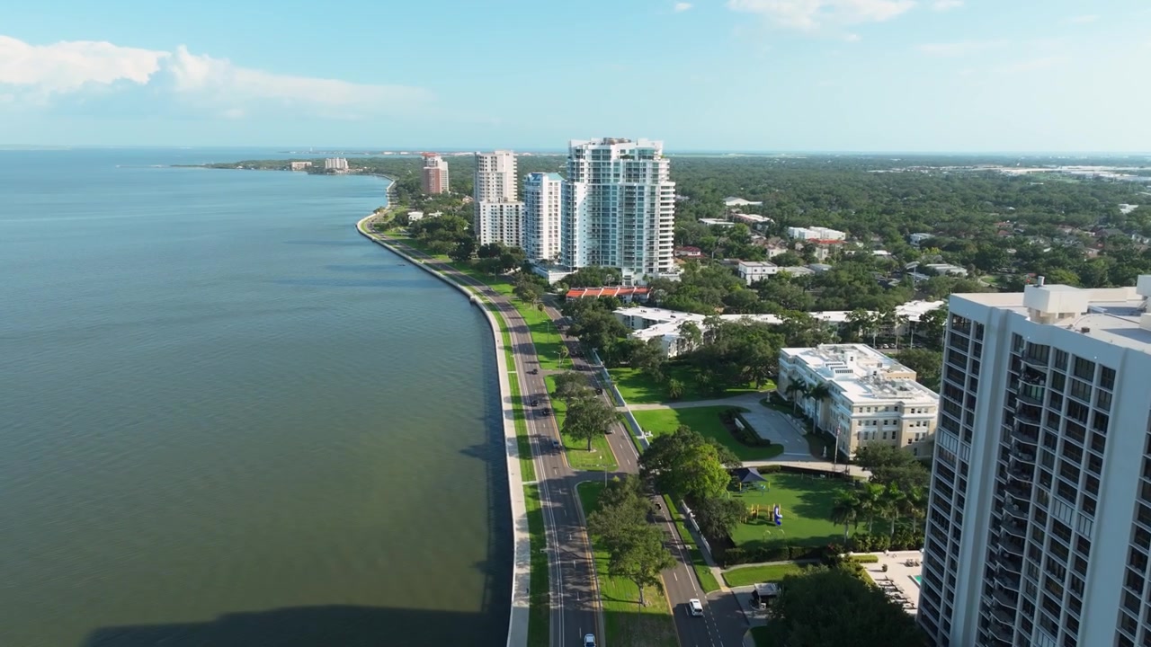 Vista aerea dall'alto del traffico che scorre lungo Bayshore Boulevard a Hyde Park di Tampa, con la passeggiata sul lungomare che incontra le acque scintillanti della baia di Hillsborough
