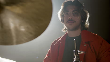 young male drummer playing drums at music studio