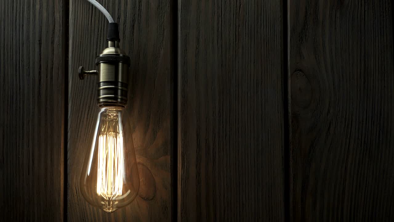 la bombilla se enciende lentamente, parpadea rápidamente en un fondo de madera