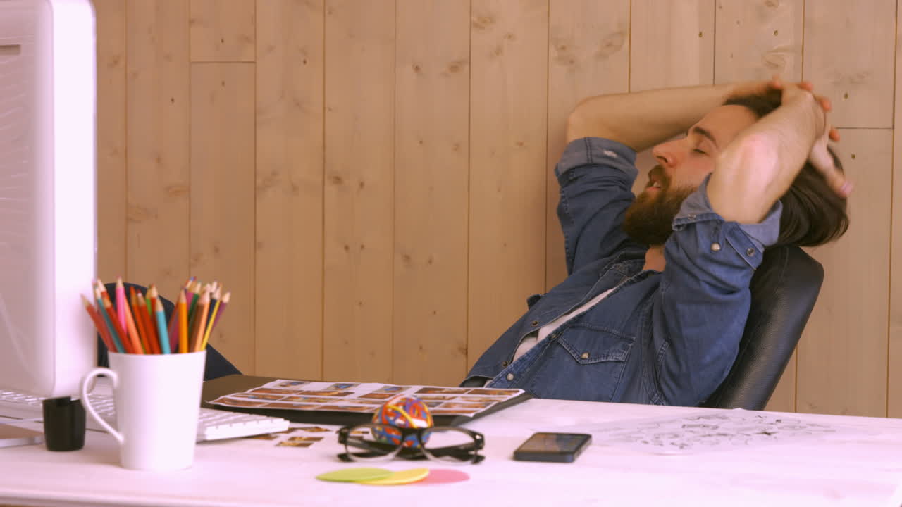 Hipsterarbeider slapper av ved pulten
