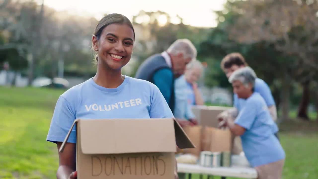 Happy Volunteer Woman Holding Donation Box in Park