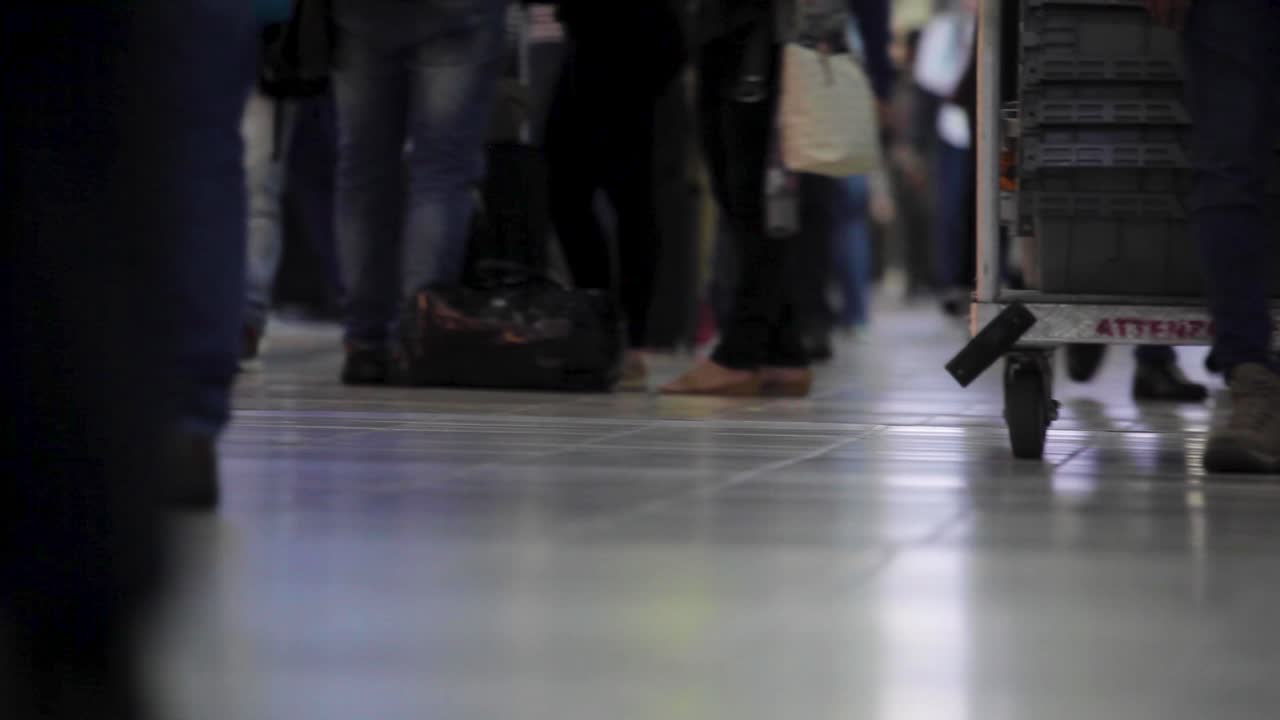 Terminal bandara yang sangat ramai dengan banyak orang membawa koper, diambil dari sudut rendah