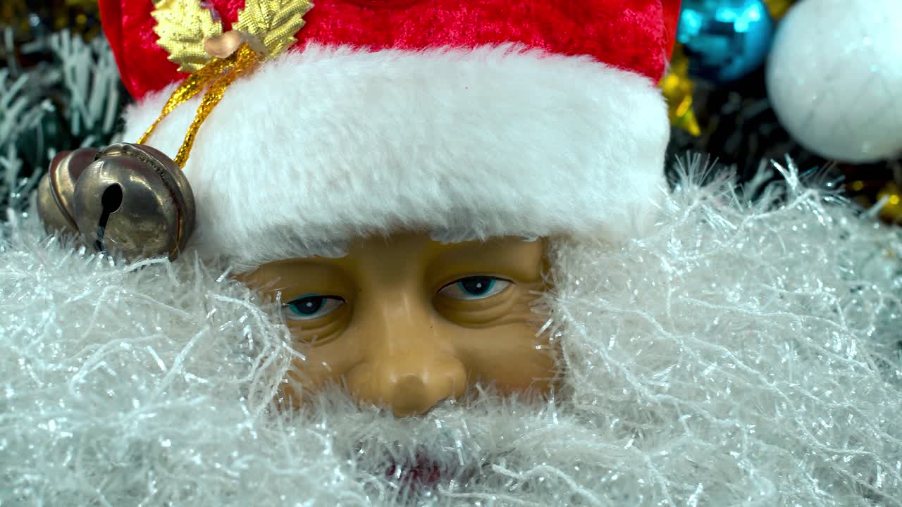Detailní jasný záběr zblízka s plynulým posunem doleva, hračka Santa Clause v červené čepici, vánoční dekorace, tradiční sváteční dárky, novoroční výzdoba, retro dárky, 4K video