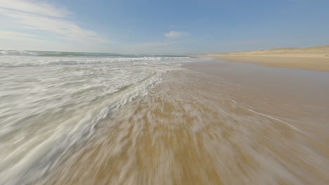 Dron-De-Carreras-Fpv-Aéreo-Volando-Sobre-Las-Aguas-Del-Mar-A-Lo-Largo-De-La-Playa,-Soustons,-Departamento-De-Landes-En-Francia