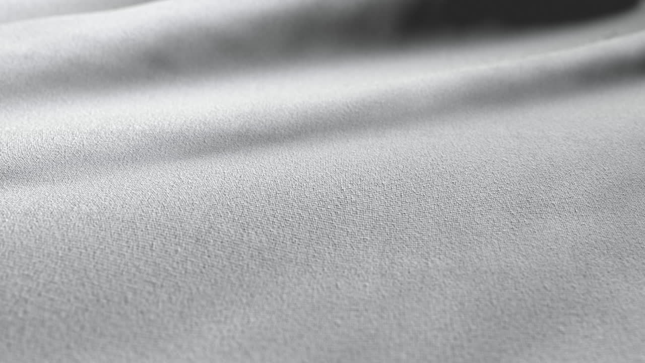 Elegantní vlnící se látkový povrch, abstraktní minimalistická smyčka pozadí.