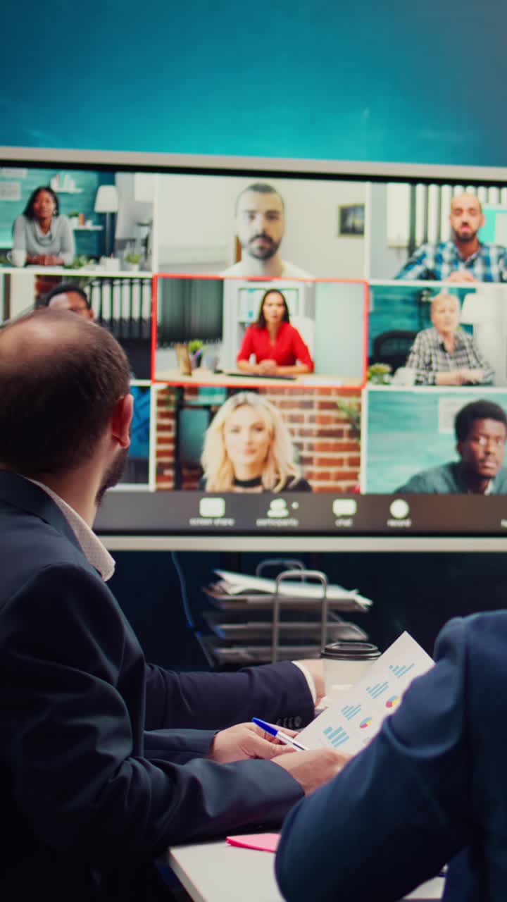 Equipo de negocios debatiendo datos durante una videoconferencia híbrida