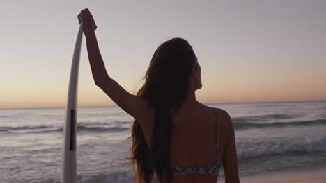 young woman relaxing on a beach at sunset