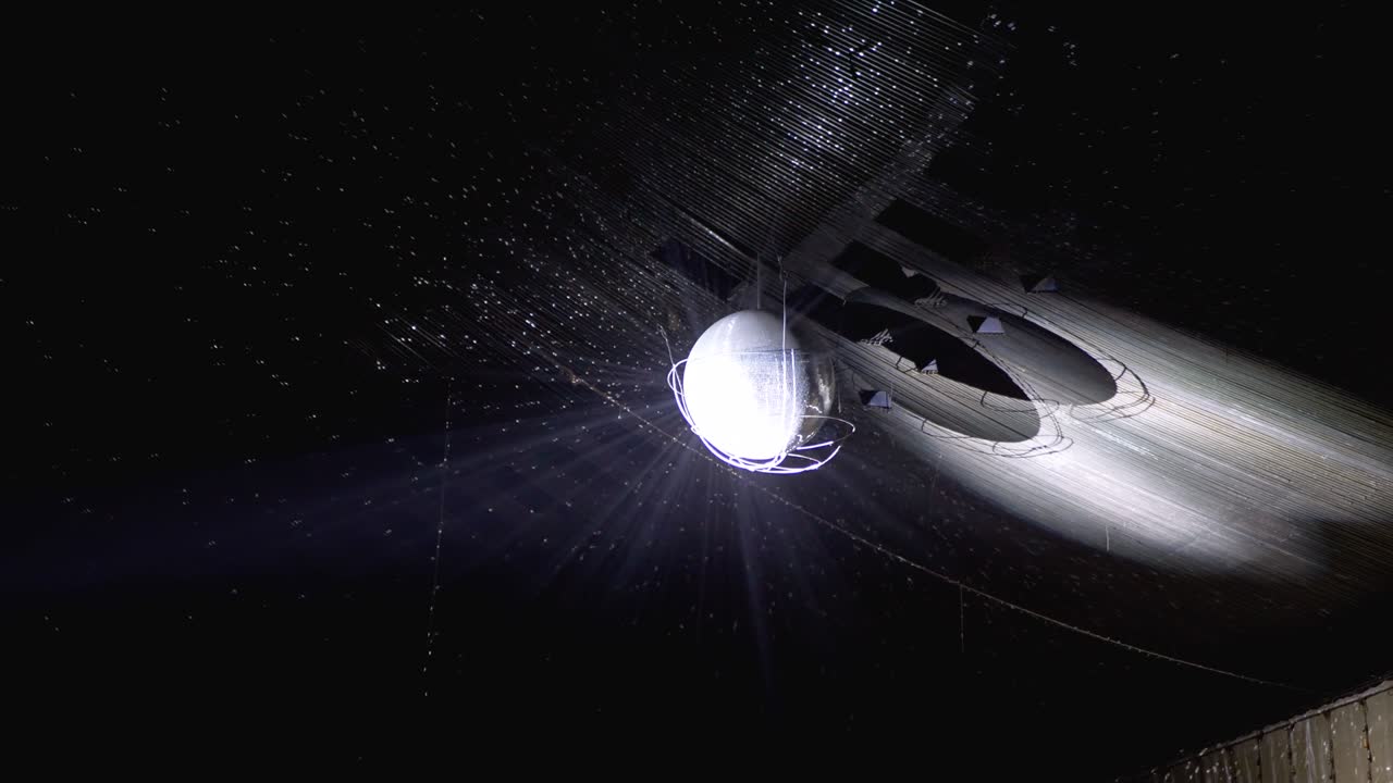 콘서트 홀 의 천장 위 에 매달린 디스코 공 은 광선 을 반사 하고 회전 한다