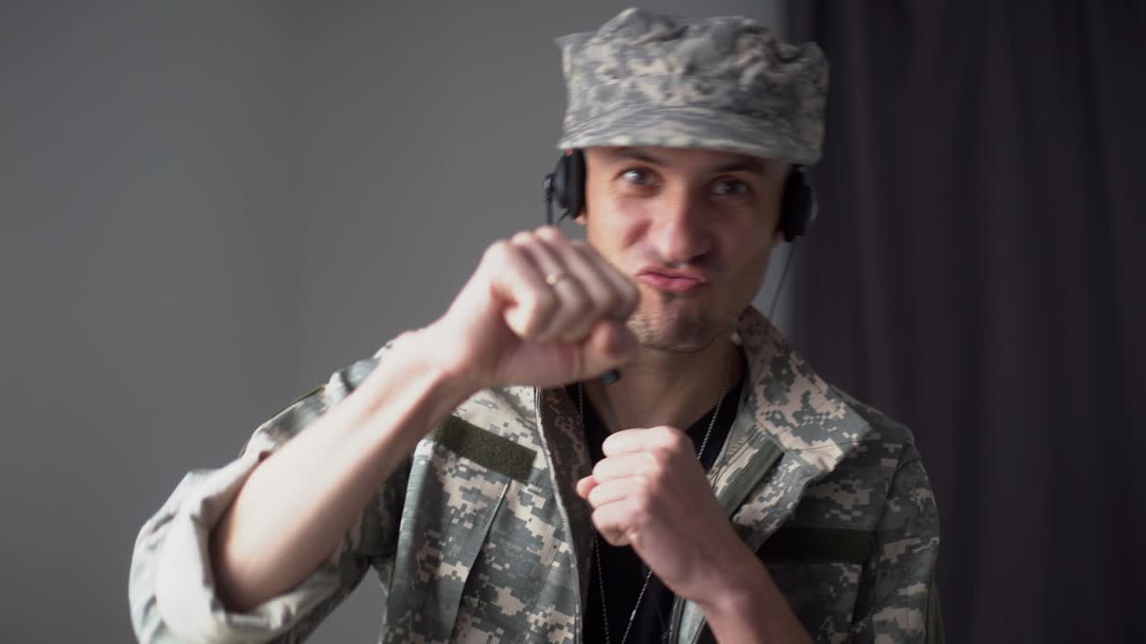 военный мужчина в наушниках говорит в замедленном режиме, глядя на камеру. видеочат pov портрет отважного мужчины-солдата, проводящего онлайн-конференцию в помещении