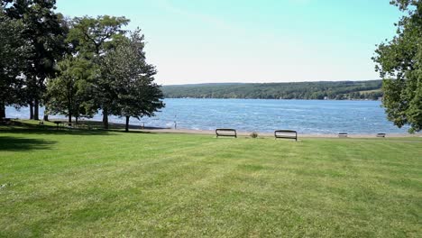 vista a nivel del suelo del parque del lago keuka en los lagos de los dedos, deslizándose de izquierda a derecha, incluyendo el campo de hierba, la playa y el agua