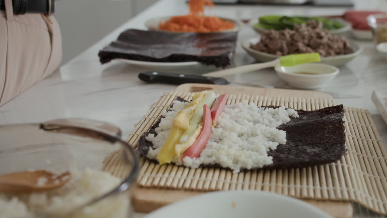 Woman Adding Ingredients when Cooking Sushi at Home