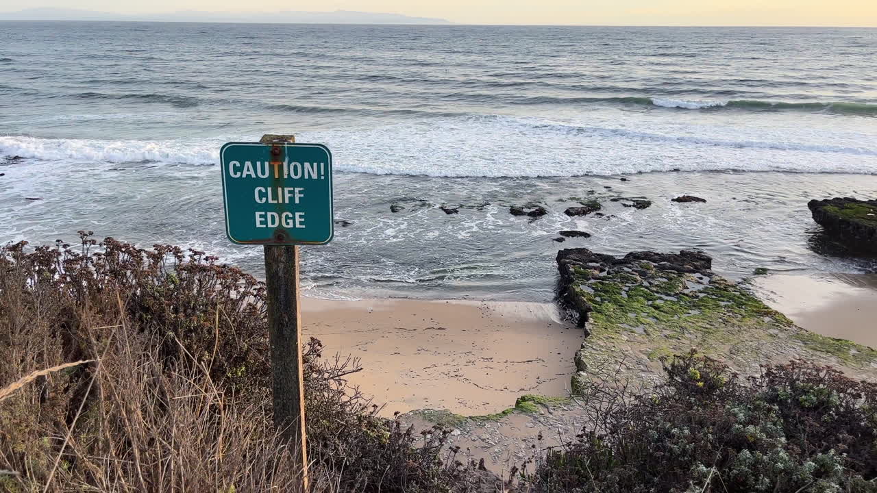 암벽 가장자리에 있는 바다 에 있는 경고 표지판, 모레에 몰리는 파도, 몬테레이 만을 내려다보는 산타크루즈
