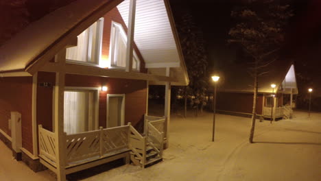 Flying-over-small-wooden-house-in-winter-evening