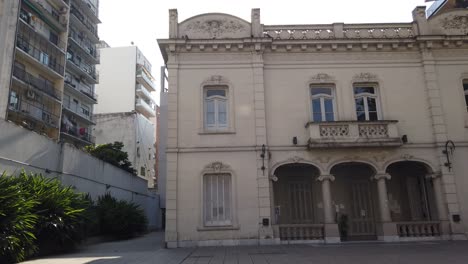 architectural contrast between colonial house and modern glass skyscraper, pan