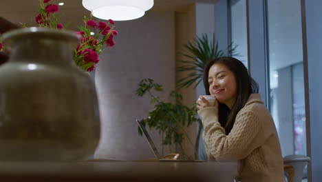 카페에서 꿈꾸고 미소 짓는 아름다운 젊은 아시아 소녀