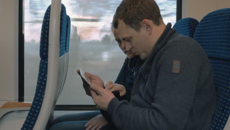 young people entertaining with pad in the train