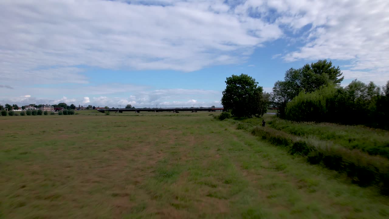 네덜란드 주트펜 의 네덜란드 홍수 지대 에 있는 이젤 강 을 따라 달리는 남성 트레일 러너 를 따라 넓은 공중 풍경