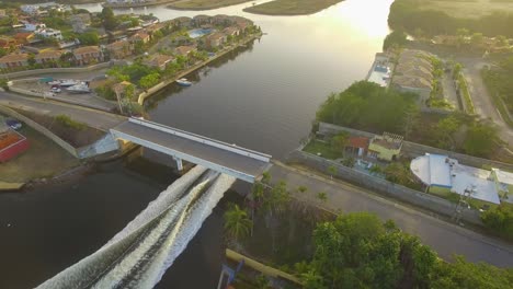 aerial view of a fast boat in the higuerote canals , in venezuela, sailing under the bridge in the golden hour