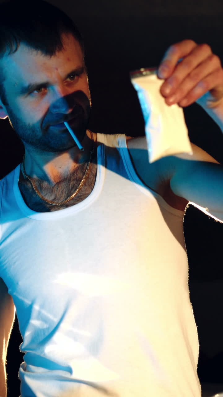 Drugs. In the underground laboratory drug dealer places packs filled with drugs Into the suitcase for further selling and distribution. Vertical video